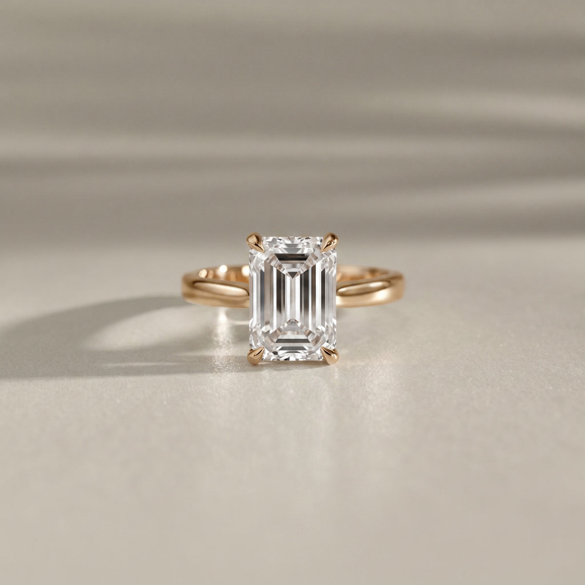 emerald cut cathedral solitaire engagement ring with tiger claw in yellow gold