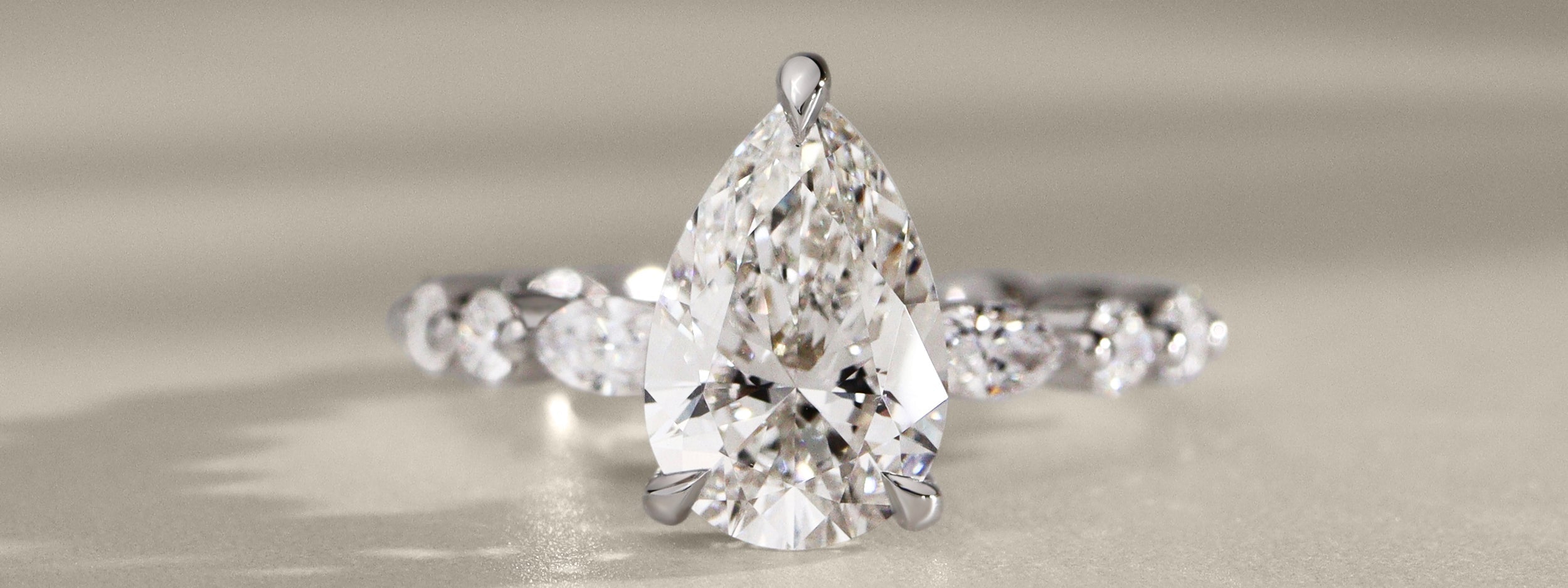 Pear diamond ring with marquise round diamond band in white gold