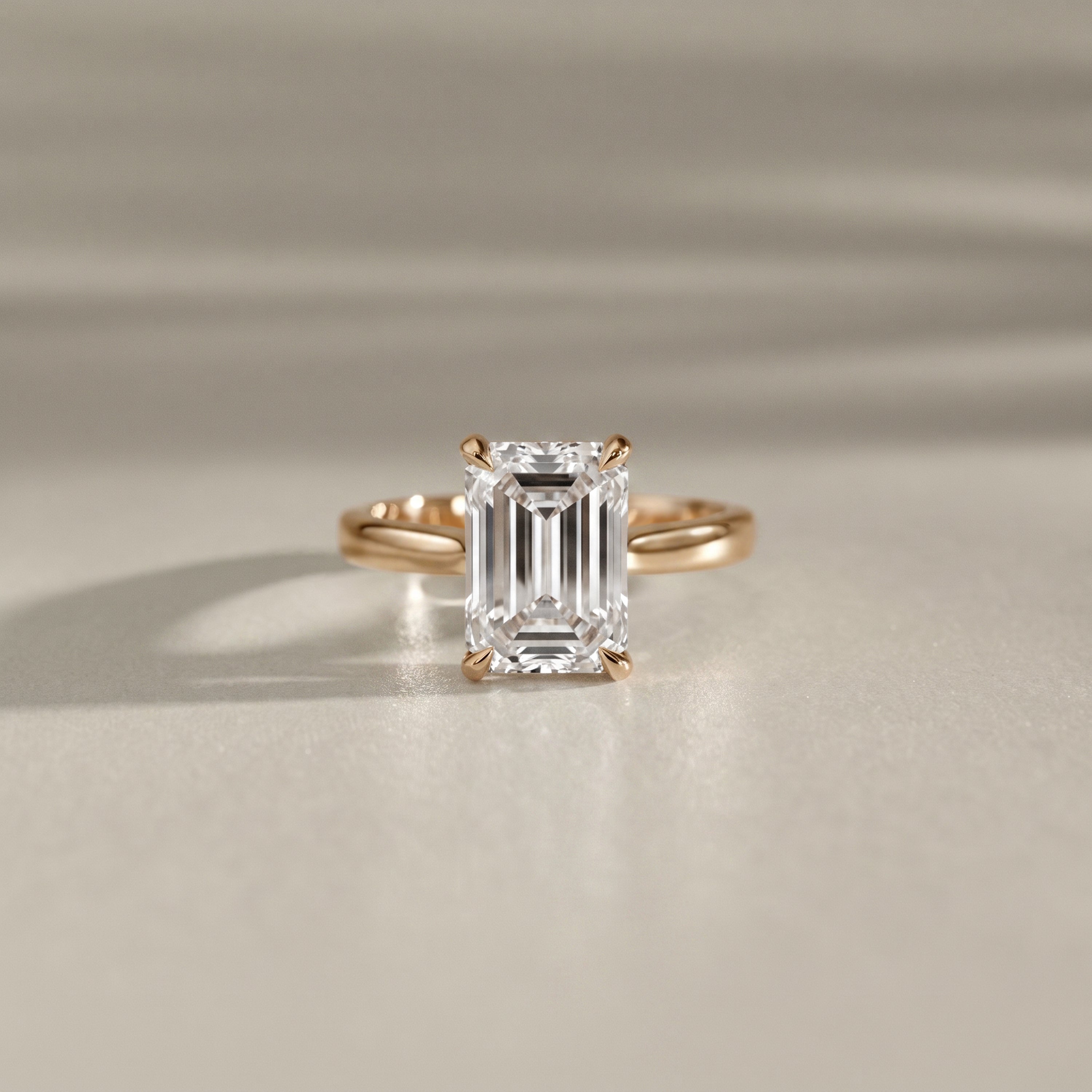 emerald cut cathedral solitaire engagement ring with tiger claw in yellow gold