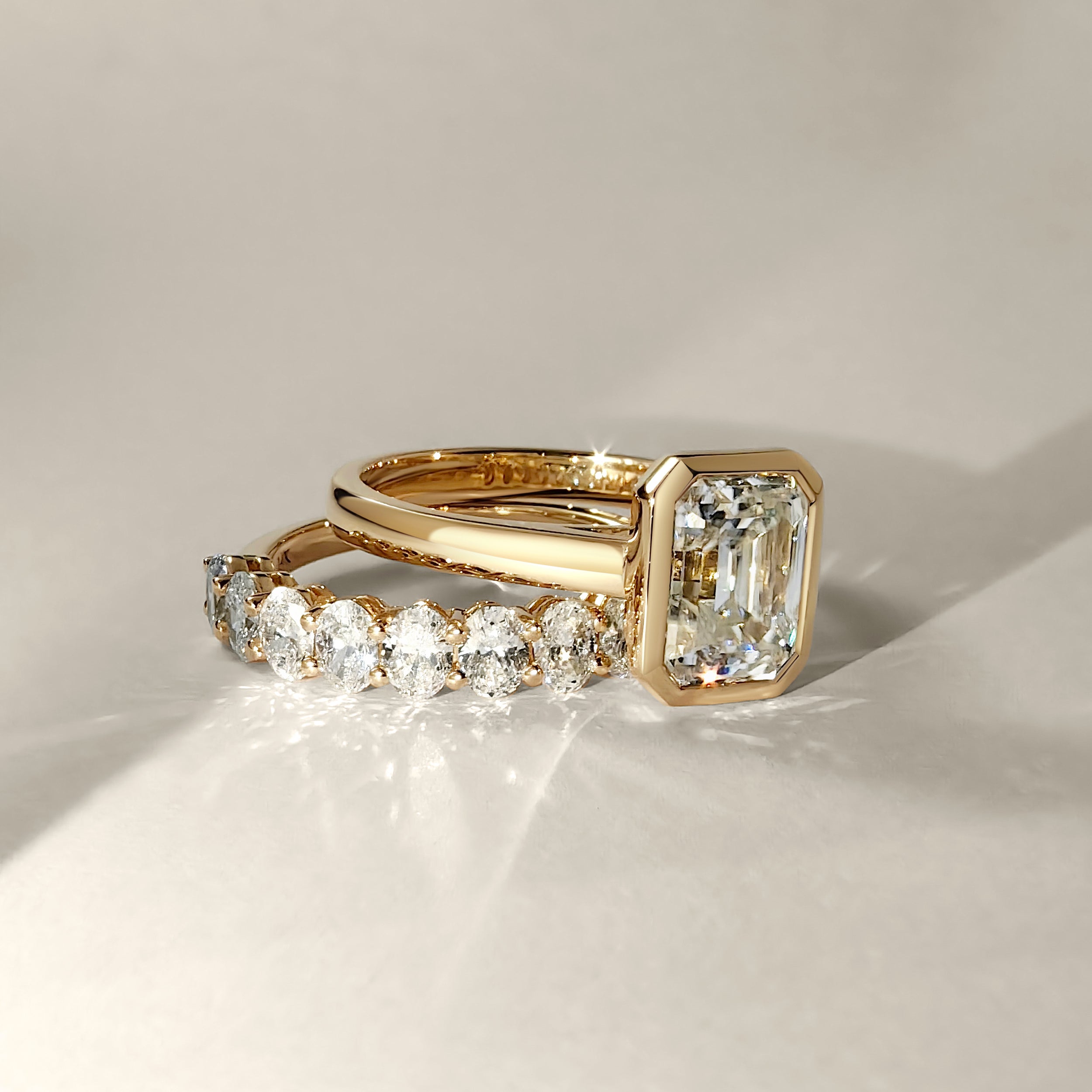 emerald bezel cathedral engagement ring stack with oval diamond eternity wedding band